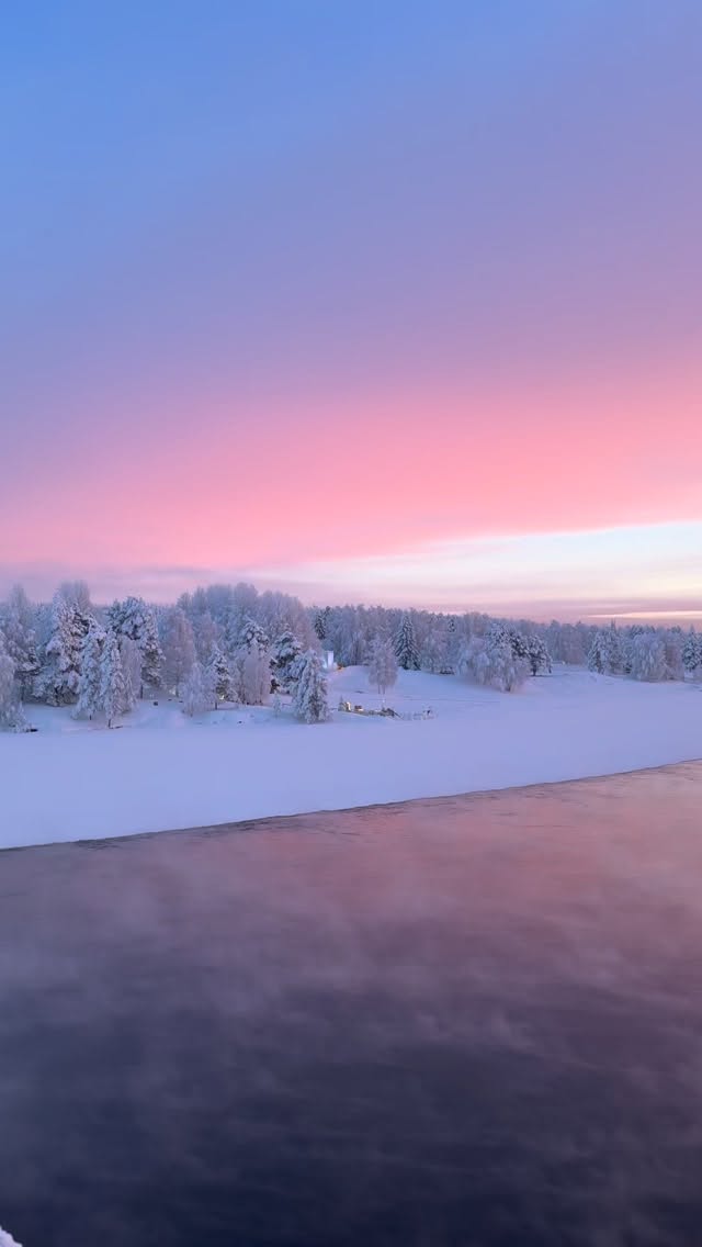 Snowy landscape at sunset with pink sky
