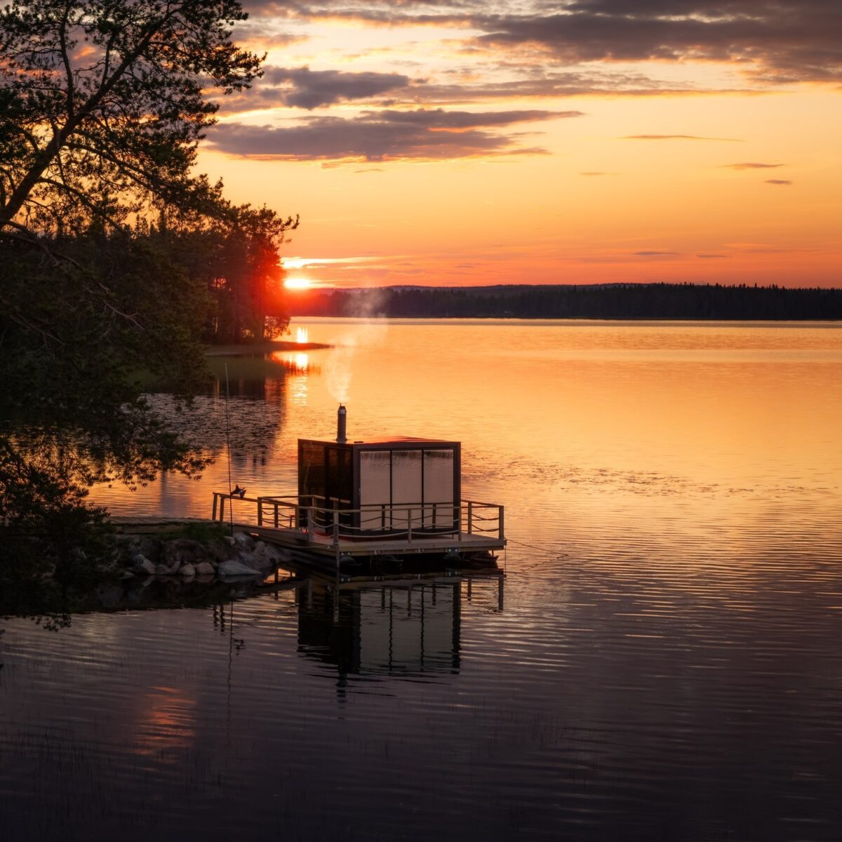 Floating sauna cabin on lake at sunset