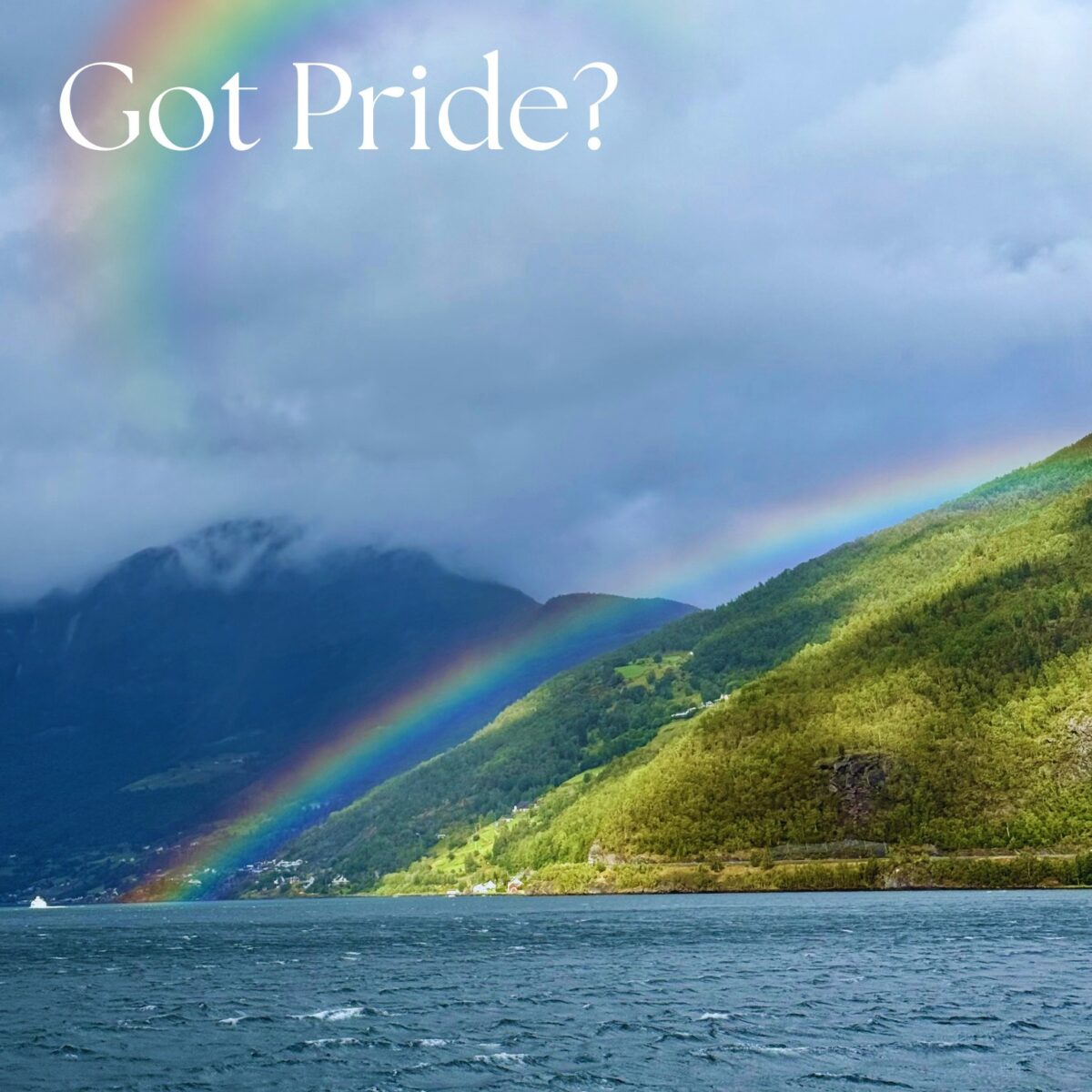 Rainbow over mountains and water with 'Got Pride?' text