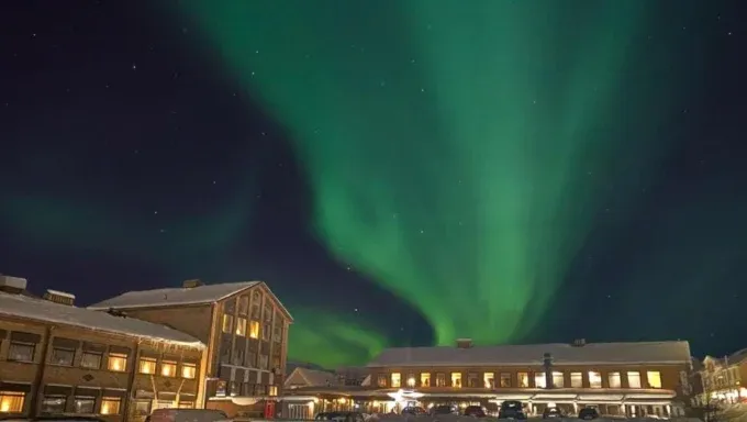 Northern lights over snowy town at night