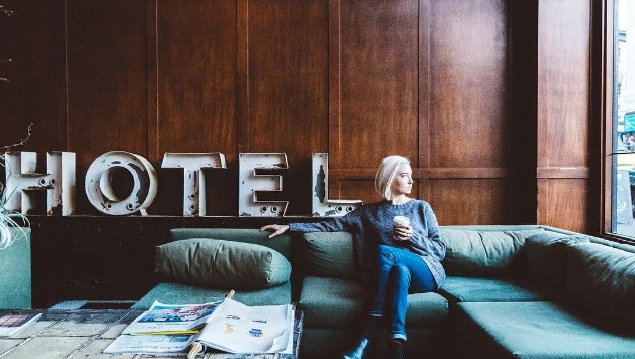 Woman sitting on couch in hotel lobby