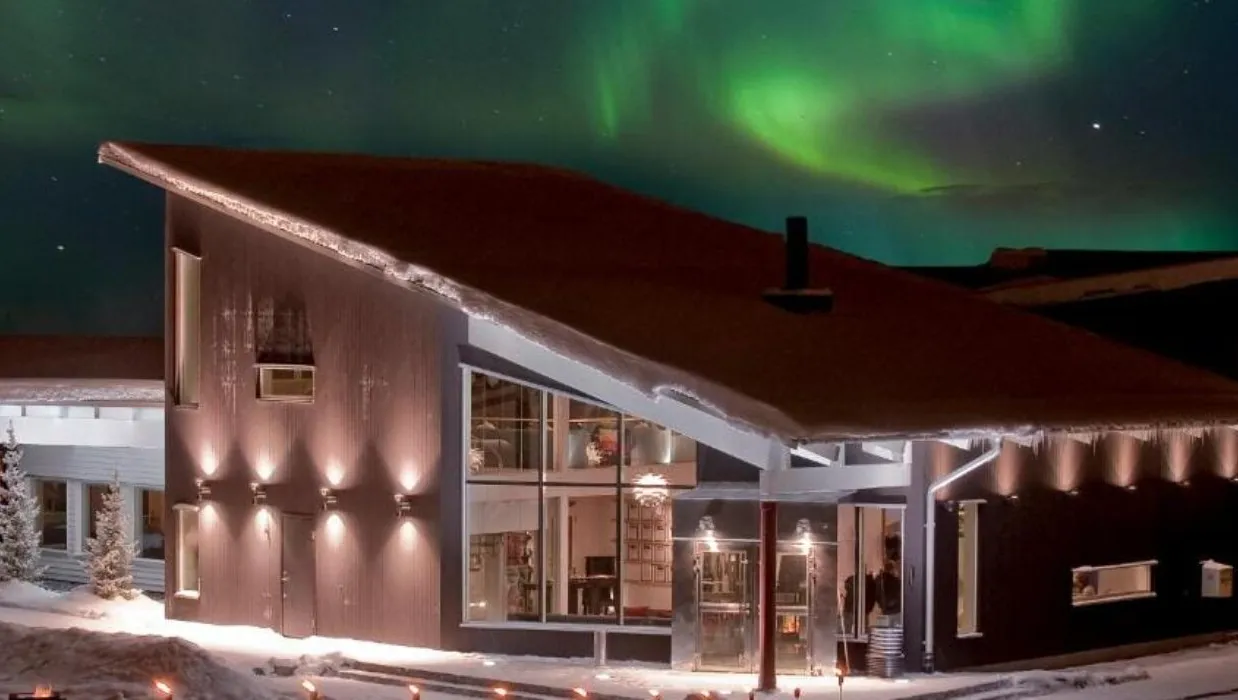 Modern snowy house under northern lights