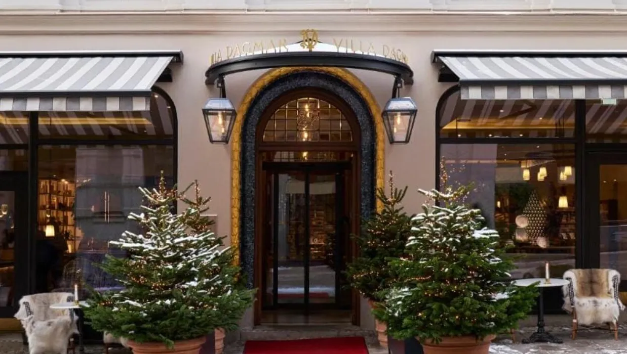 Elegant hotel entrance with snow-dusted Christmas trees