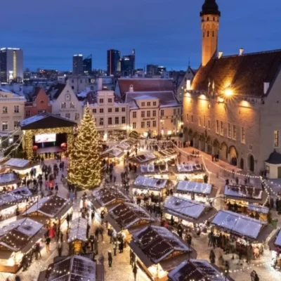 Christmas market in snowy European town square at dusk